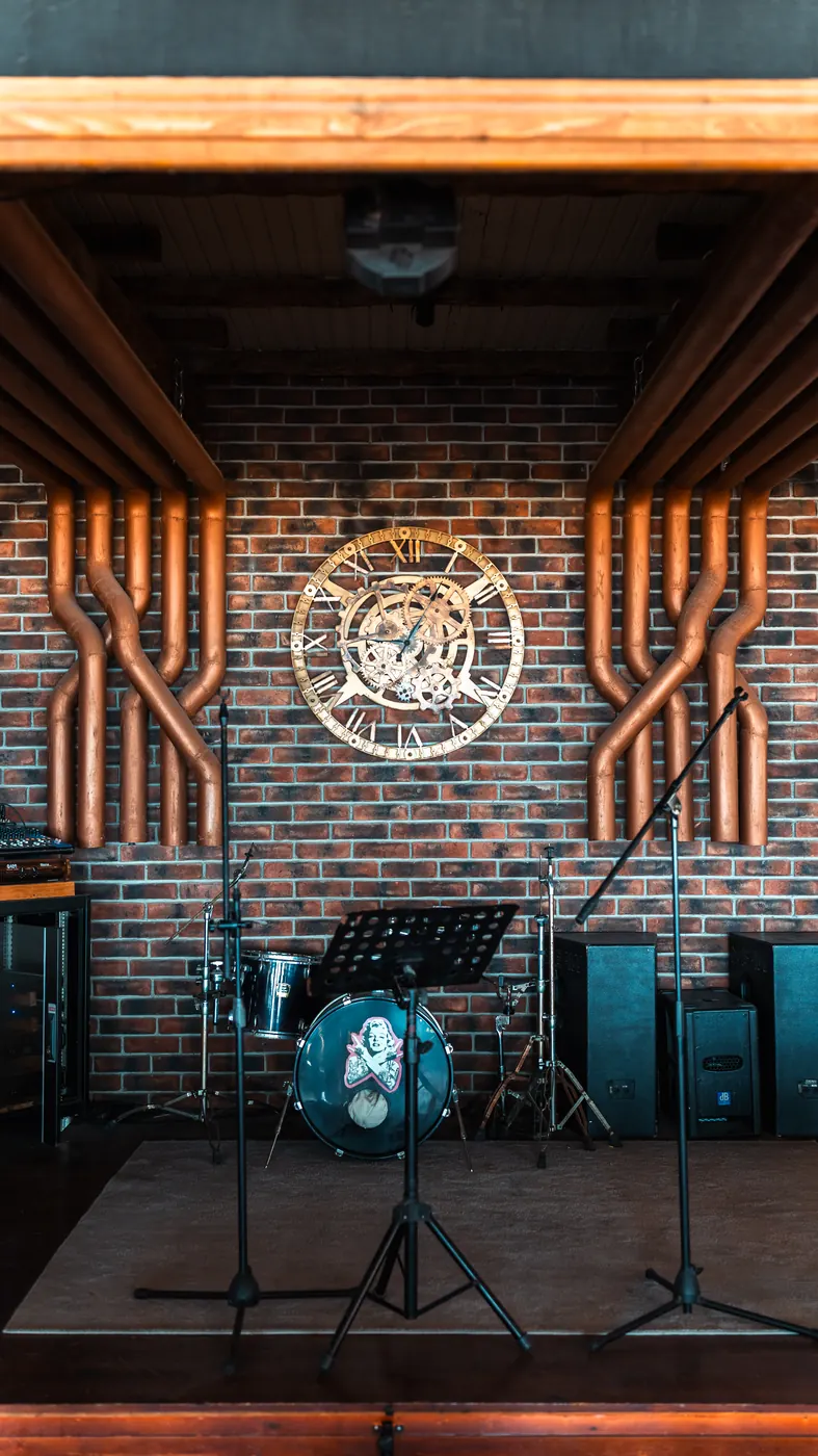 Stage with drums and microphones in front of a brick wall