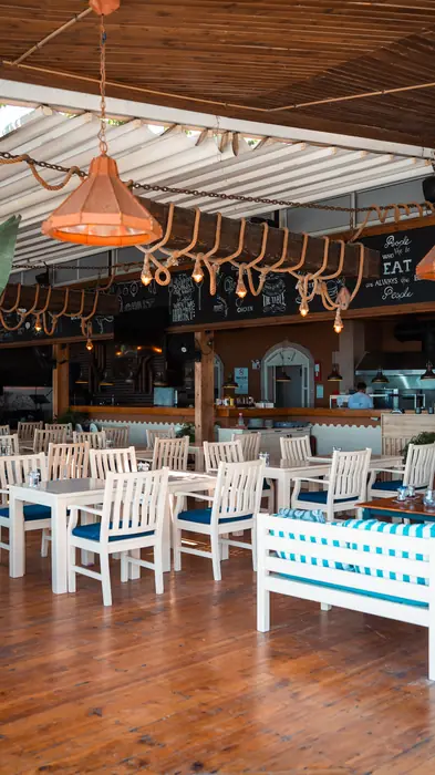 Open-air seating with white tables and blue cushions