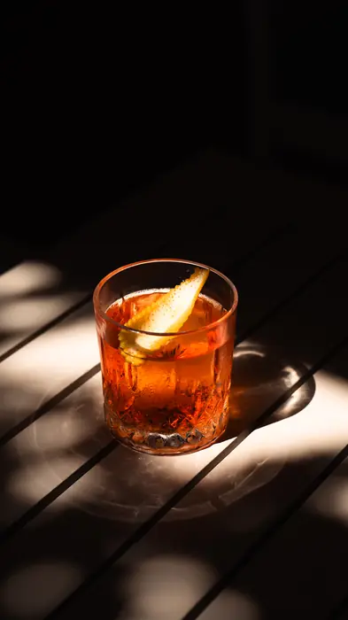 Cocktail with an orange slice in sunlight