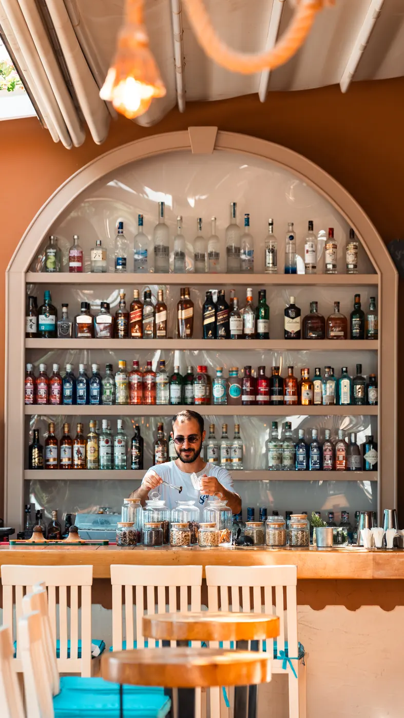 Bartender mixing a cocktail in front of the arched bar shelves