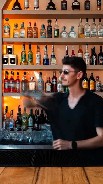 Bartender in front of the bar shelves
