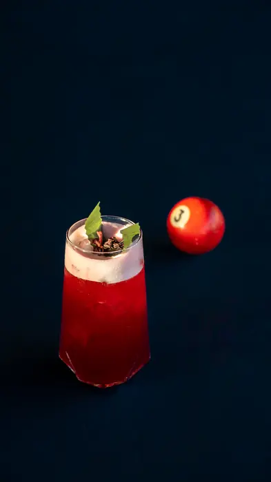 Red cocktail next to a billiard ball