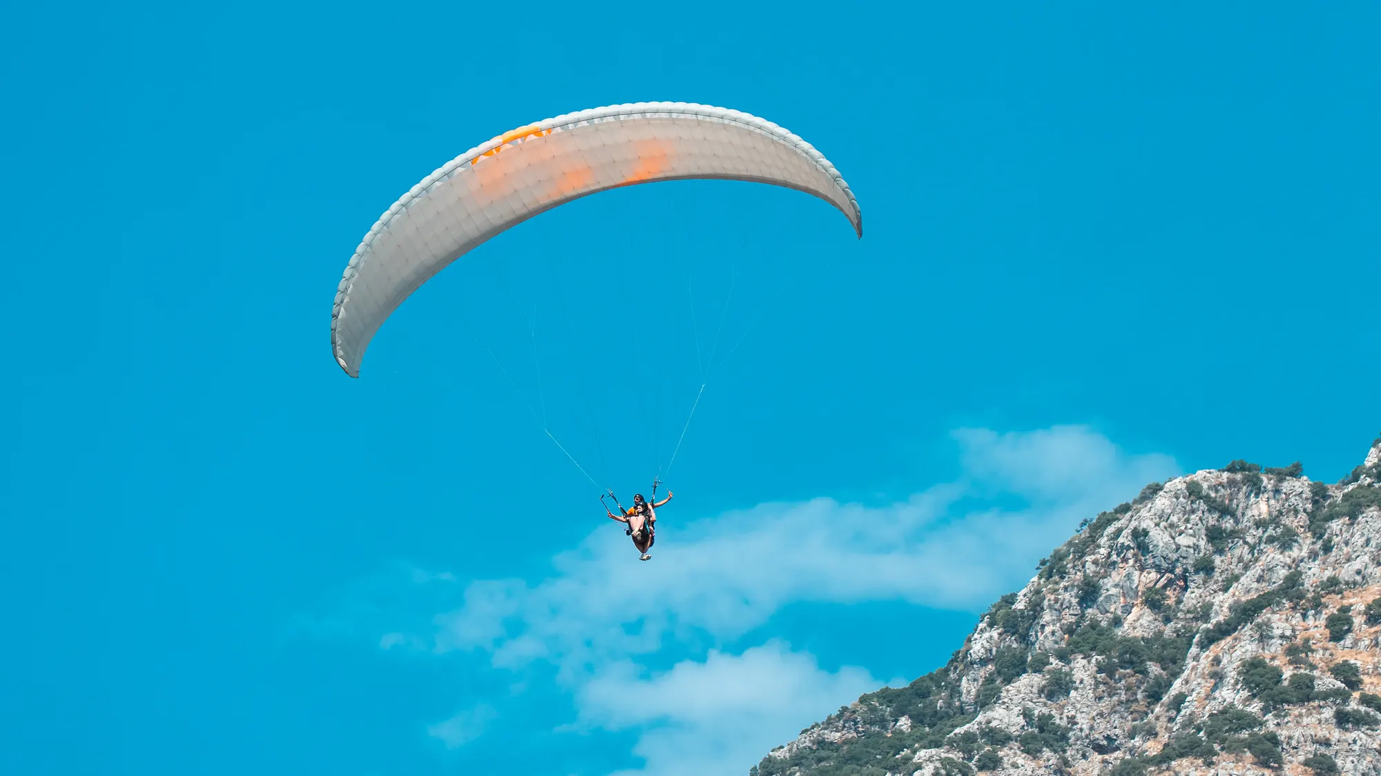 A paraglider soaring over Babadağ in Ölüdeniz